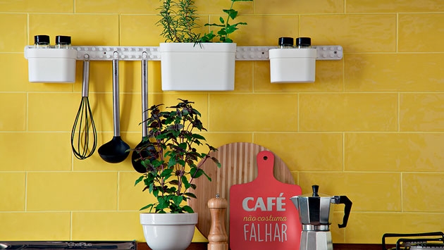 Cozinha integrada com mosaicos amarelos e armários pretos